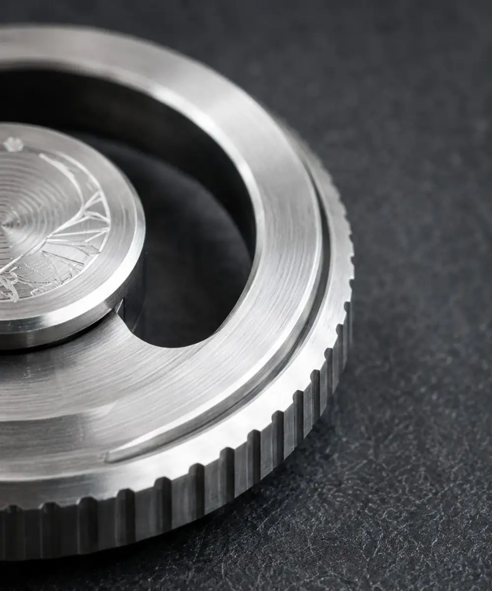 Close-up of a stainless steel EDC fidget tool showing a clean brushed metal surface and machined edge detail.